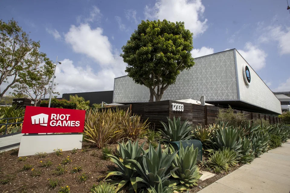 The Riot Games campus in Los Angeles: the red monument sign at the entrance, the triangle-patterned facade of 12333 behind it